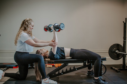Coach spotting a client during dumbbell bench press