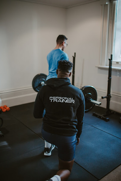 Personal trainer coaching a client through a barbell squat